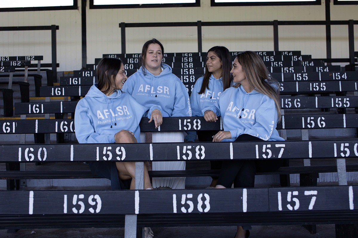 Kylie and her AFL SportsReady team sitting on the bleachers