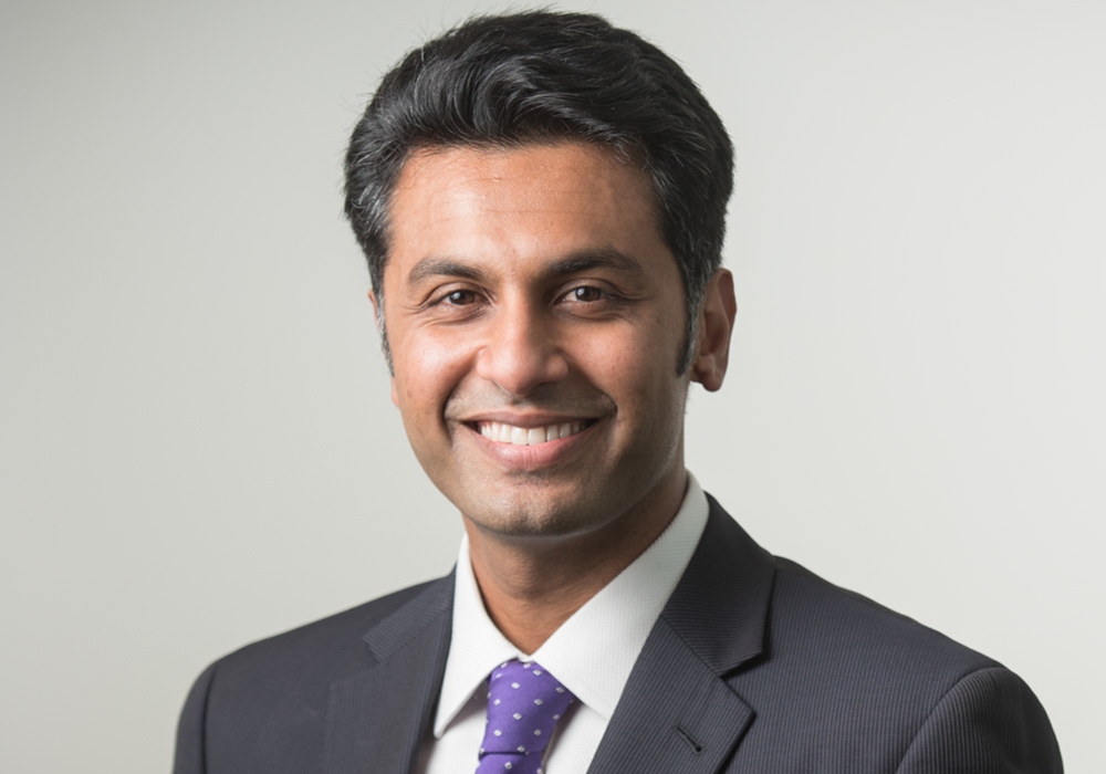 Photo of Professor Shamal Dass. He has black hair and is wearing a white shirt and purple tie, with a black blazer.