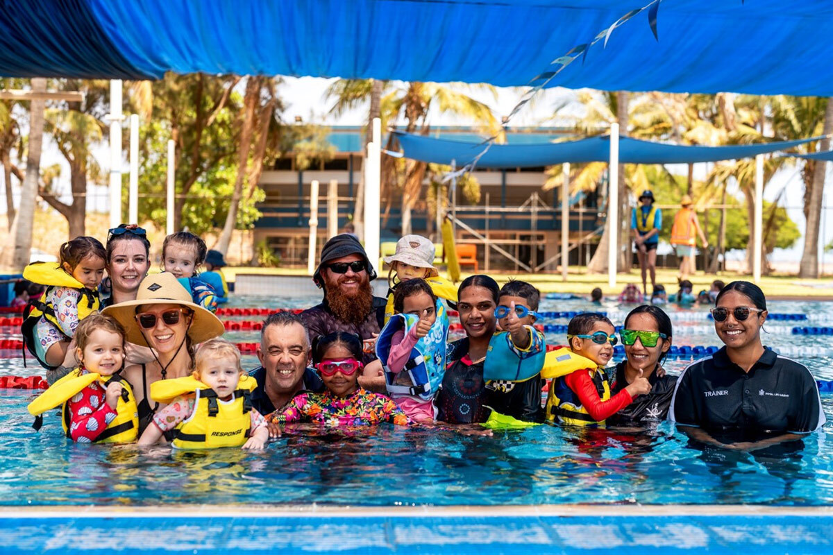 Group of diverse people in a swimming pool smiling at the camera