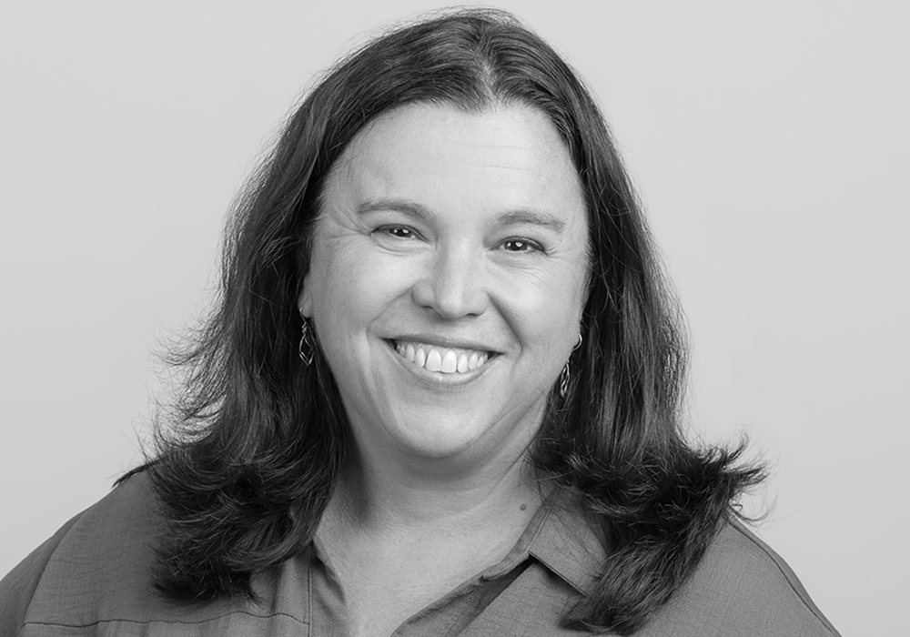 Photo of a woman with dark hair. She is smiling at the camera.