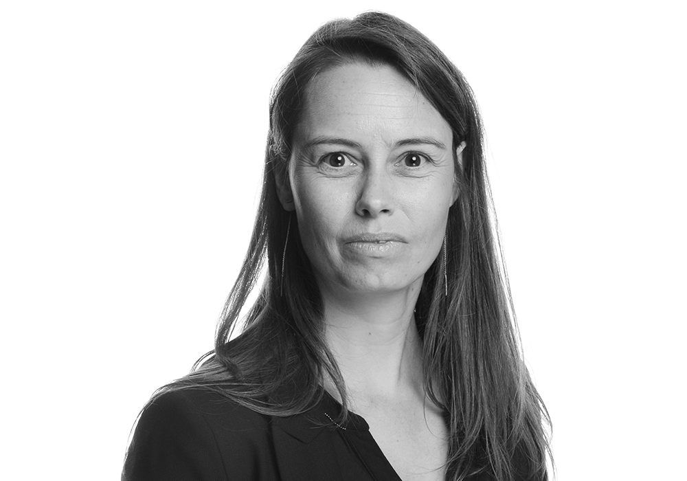 Photo of Hannelore Verdonckt. She has long dark hair and is wearing a black blouse, looking at the camera.