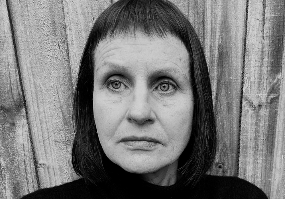 Photo of a woman with dark hair. She is smiling at the camera.